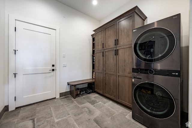 201 N Kings Peak Ct Unit Cp-23, Heber City, UT 84032 - washroom featuring stacked washer and clothes dryer, cabinet space, baseboards, and light stone finish floors