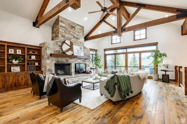2938 Daybreaker Dr, Park City, UT 84098 - living area featuring high vaulted ceiling, beam ceiling, light wood-style flooring, a stone fireplace, and a ceiling fan
