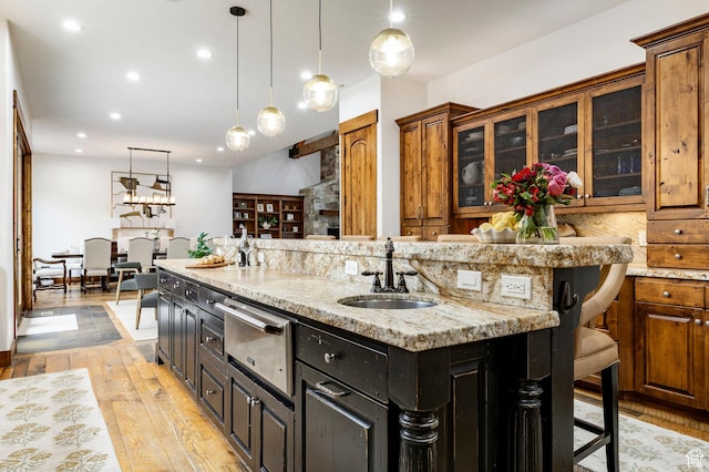2938 Daybreaker Dr, Park City, UT 84098 - kitchen featuring a warming drawer, a sink, a center island with sink, a kitchen breakfast bar, and light wood-style floors