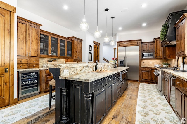 2938 Daybreaker Dr, Park City, UT 84098 - kitchen with beverage cooler, built in appliances, a kitchen island, light wood-type flooring, and tasteful backsplash