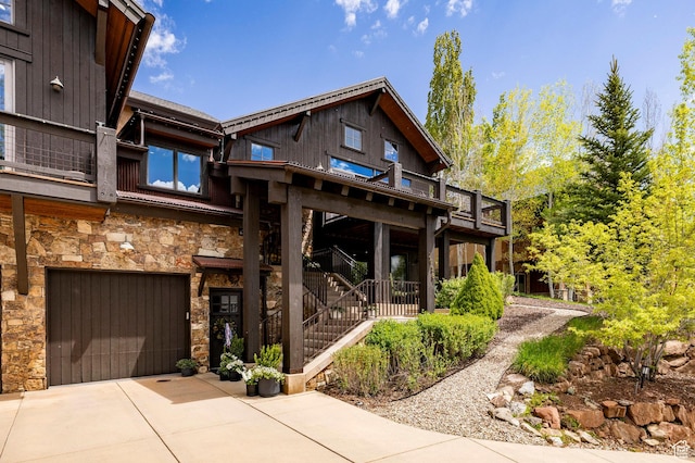 2938 Daybreaker Dr, Park City, UT 84098 - back of house featuring stone siding, concrete driveway, a garage, and a balcony
