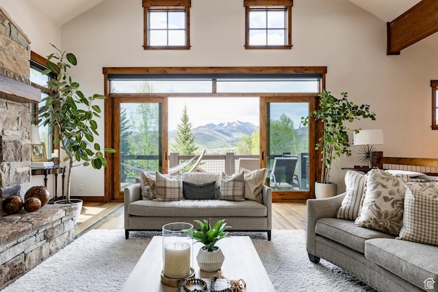 2938 Daybreaker Dr, Park City, UT 84098 - living area featuring high vaulted ceiling, wood finished floors, a stone fireplace, and a mountain view