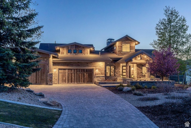5925 Mountain Ranch Dr, Park City, UT 84098 - view of front of home with decorative driveway, an attached garage, stone siding, a porch, and a chimney