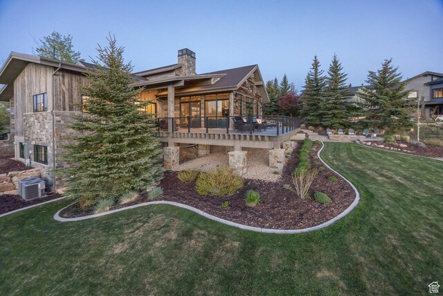 5925 Mountain Ranch Dr, Park City, UT 84098 - back of house featuring a chimney, a lawn, a wooden deck, central AC, and a sunroom