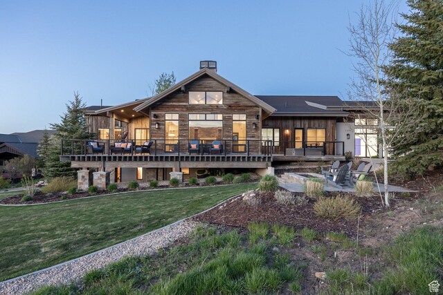 5925 Mountain Ranch Dr, Park City, UT 84098 - back of property featuring a deck, a lawn, a chimney, and stone siding