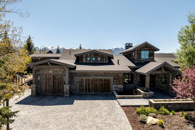 5925 Mountain Ranch Dr, Park City, UT 84098 - view of front of home with stone siding, a chimney, decorative driveway, and a garage