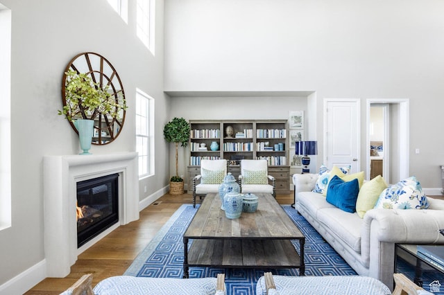 1460 Rocky Mountain Way Unit 223, Francis, UT 84036 - living area featuring a towering ceiling, baseboards, wood finished floors, and a glass covered fireplace
