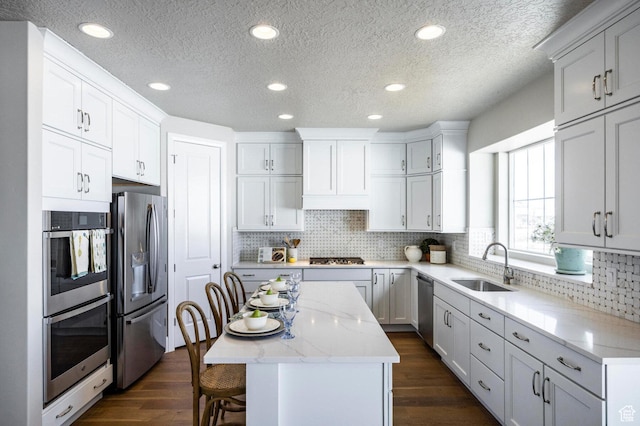 1460 Rocky Mountain Way Unit 223, Francis, UT 84036 - kitchen with appliances with stainless steel finishes, a sink, a center island, a textured ceiling, and dark wood-type flooring