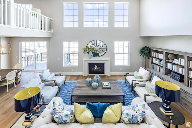 1460 Rocky Mountain Way Unit 223, Francis, UT 84036 - living room featuring wood finished floors, a lit fireplace, a towering ceiling, and baseboards
