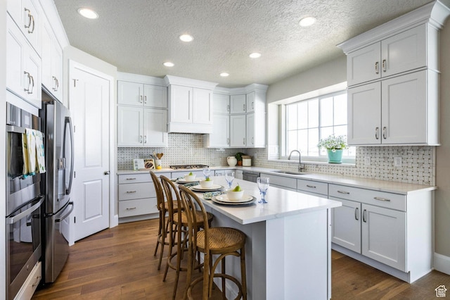 1460 Rocky Mountain Way Unit 223, Francis, UT 84036 - kitchen featuring stainless steel appliances, a sink, dark wood-style floors, a breakfast bar area, and light countertops