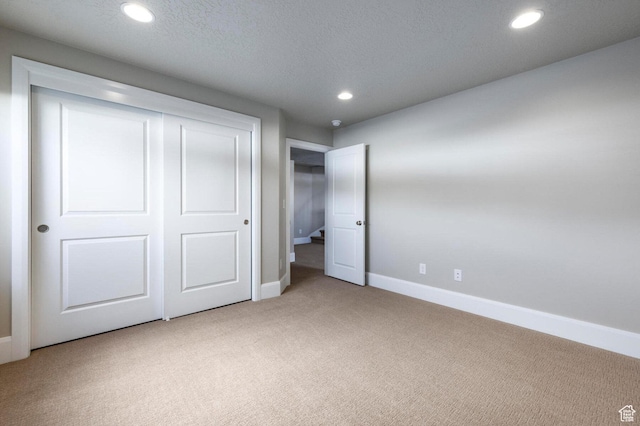1460 Rocky Mountain Way Unit 223, Francis, UT 84036 - unfurnished bedroom with light carpet, recessed lighting, baseboards, a closet, and a textured ceiling