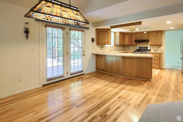 5725 S 1075 E, South Ogden, UT 84405 - kitchen featuring appliances with stainless steel finishes, under cabinet range hood, light wood-style flooring, light countertops, and a peninsula