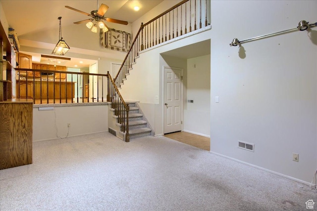 5725 S 1075 E, South Ogden, UT 84405 - unfurnished living room with carpet flooring, a ceiling fan, stairway, a high ceiling, and baseboards