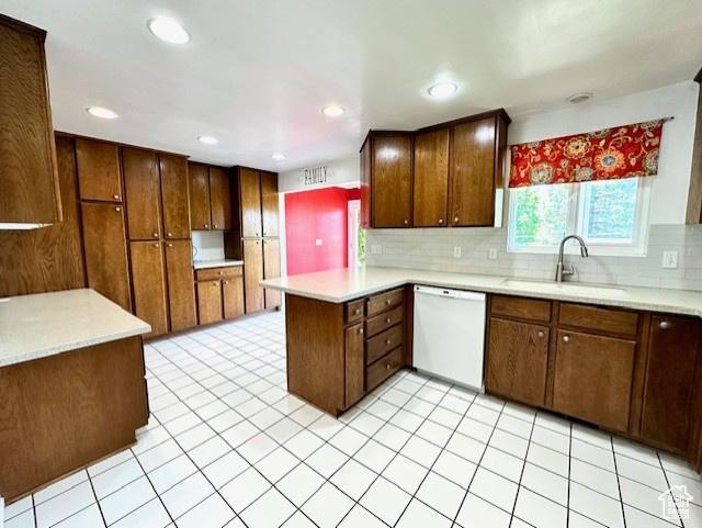 558 E Center St, Kaysville, UT 84037 - kitchen featuring dishwasher, a sink, a peninsula, decorative backsplash, and light countertops