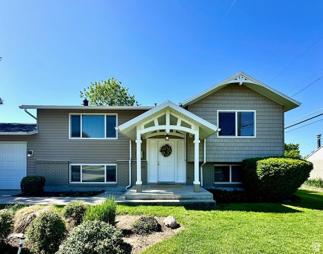 558 E Center St, Kaysville, UT 84037 - split level home featuring a front yard, brick siding, and an attached garage