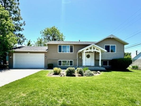 558 E Center St, Kaysville, UT 84037 - split foyer home with an attached garage, a front lawn, and concrete driveway