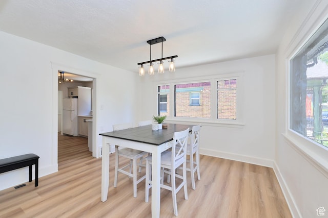 557 E Cleveland Ave, Salt Lake City, UT 84105 - dining area featuring light wood-type flooring, a chandelier, and baseboards