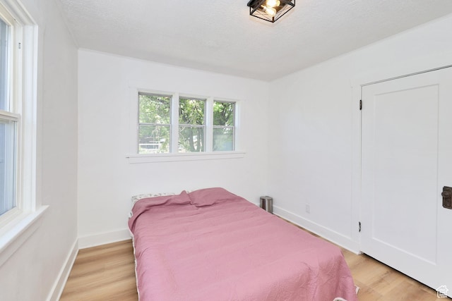 557 E Cleveland Ave, Salt Lake City, UT 84105 - bedroom with light wood finished floors, baseboards, and a textured ceiling