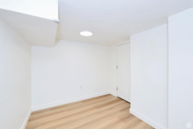 557 E Cleveland Ave, Salt Lake City, UT 84105 - spare room with light wood-style flooring, baseboards, and a textured ceiling