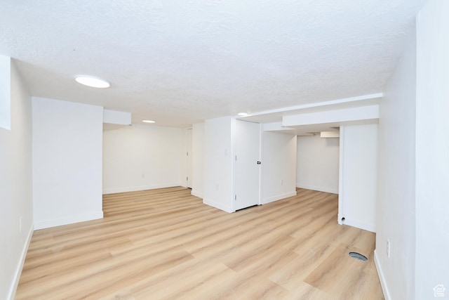 557 E Cleveland Ave, Salt Lake City, UT 84105 - finished below grade area featuring baseboards, light wood finished floors, and a textured ceiling