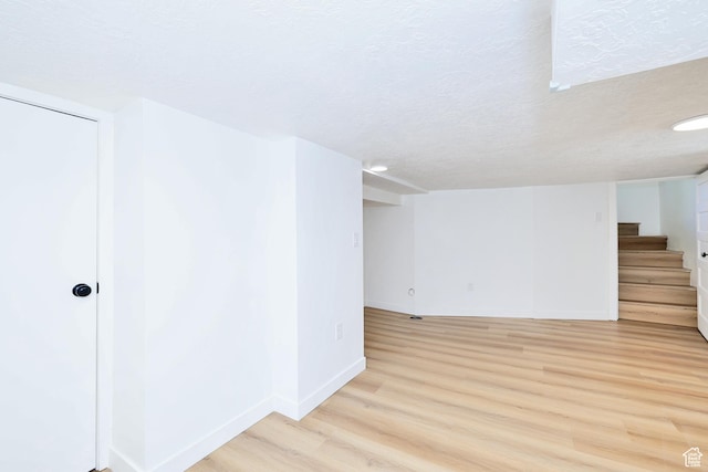 557 E Cleveland Ave, Salt Lake City, UT 84105 - finished basement featuring light wood-style flooring, stairway, baseboards, and a textured ceiling