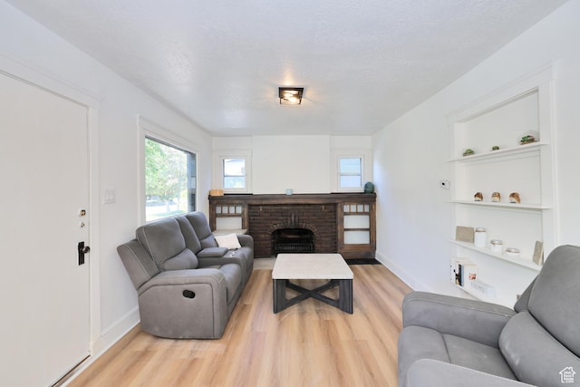 557 E Cleveland Ave, Salt Lake City, UT 84105 - living room with light wood finished floors, a brick fireplace, and baseboards