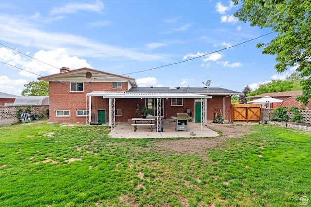5824 S 2150 W, Roy, UT 84067 - back of property with a gate, brick siding, and a patio area