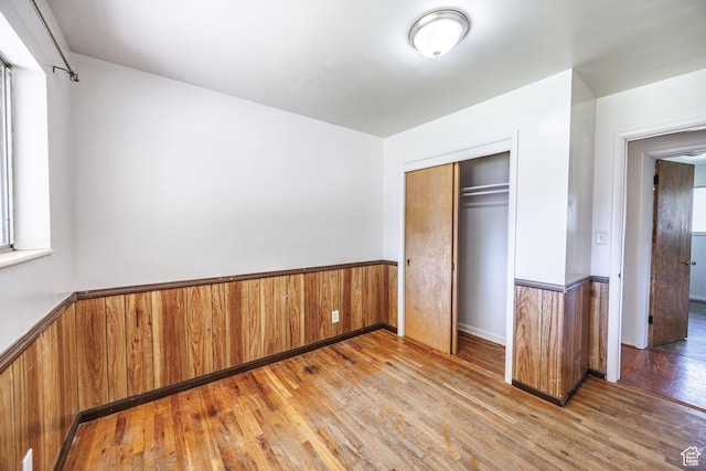 253 S 100 W, American Fork, UT 84003 - unfurnished bedroom featuring a wainscoted wall, wood-type flooring, a closet, and wooden walls