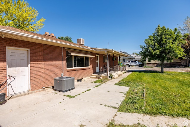 253 S 100 W, American Fork, UT 84003 - view of home's exterior with central AC, brick siding, a lawn, and a chimney