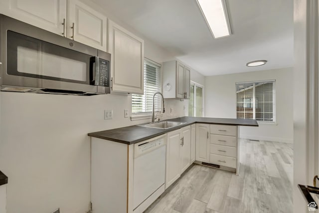 2240 S Lorin Cir W, Ogden, UT 84401 - kitchen with dishwasher, stainless steel microwave, a sink, a peninsula, and dark countertops