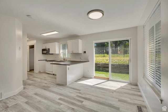 2240 S Lorin Cir W, Ogden, UT 84401 - kitchen featuring dark countertops, white cabinetry, light wood finished floors, and baseboards