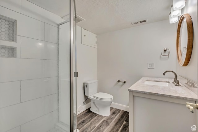 2240 S Lorin Cir W, Ogden, UT 84401 - bathroom with wood finished floors, vanity, toilet, a stall shower, and a textured ceiling