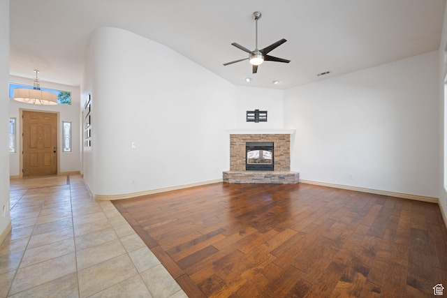 42 N 1100 W, St George, UT 84770 - unfurnished living room with vaulted ceiling, a ceiling fan, baseboards, light wood-type flooring, and a stone fireplace