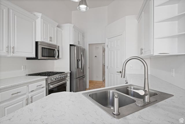 42 N 1100 W, St George, UT 84770 - kitchen with appliances with stainless steel finishes, a sink, open shelves, white cabinets, and light stone countertops