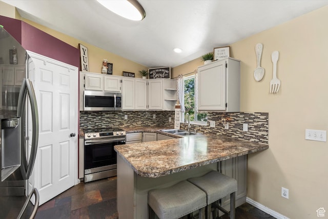 3916 W 4800 S, Roy, UT 84067 - kitchen with appliances with stainless steel finishes, a sink, a peninsula, and decorative backsplash