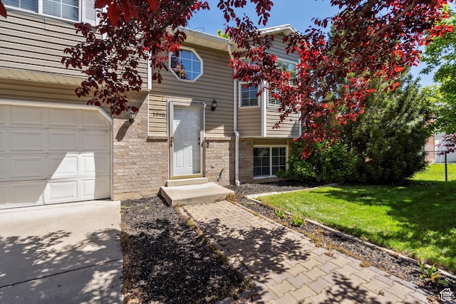 3916 W 4800 S, Roy, UT 84067 - view of front of property with stone siding, a front yard, a garage, and driveway