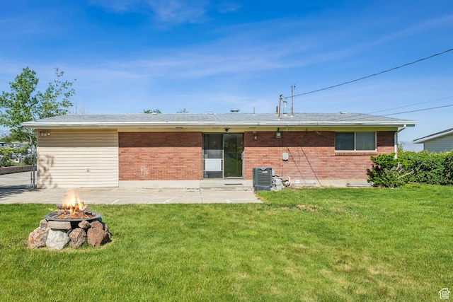 295 S 2nd St, Tooele, UT 84074 - back of property featuring an outdoor fire pit, brick siding, and a lawn