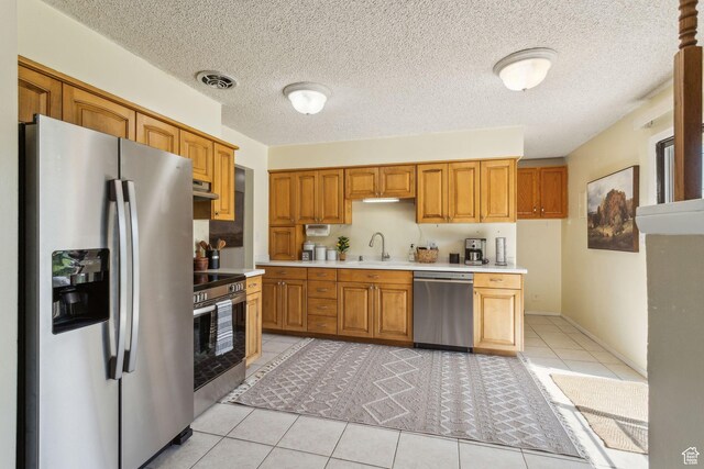 295 S 2nd St, Tooele, UT 84074 - kitchen with stainless steel appliances, light countertops, a sink, extractor fan, and light tile patterned floors