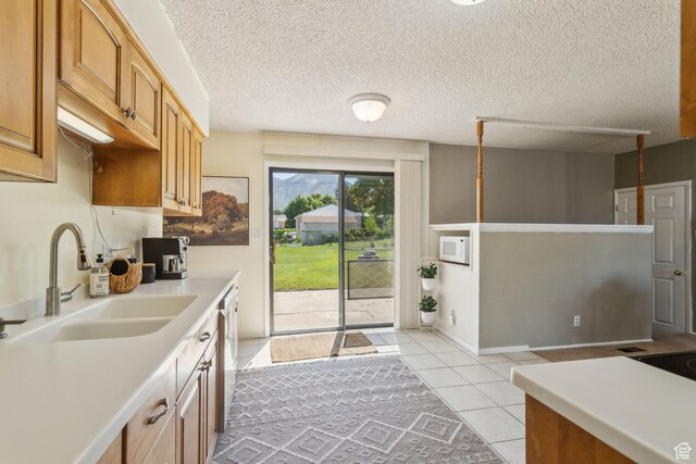 295 S 2nd St, Tooele, UT 84074 - kitchen featuring a sink, light countertops, light tile patterned flooring, stainless steel dishwasher, and a textured ceiling