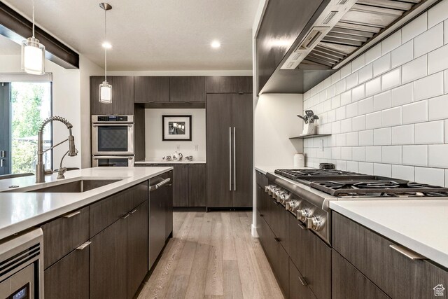 260 W 500 N Unit 4, Salt Lake City, UT 84103 - kitchen featuring a sink, extractor fan, appliances with stainless steel finishes, dark brown cabinetry, and light wood finished floors