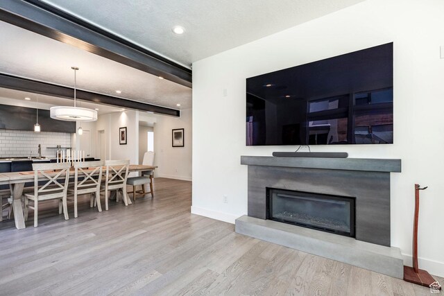 260 W 500 N Unit 4, Salt Lake City, UT 84103 - living area featuring wood finished floors, a glass covered fireplace, baseboards, recessed lighting, and beam ceiling