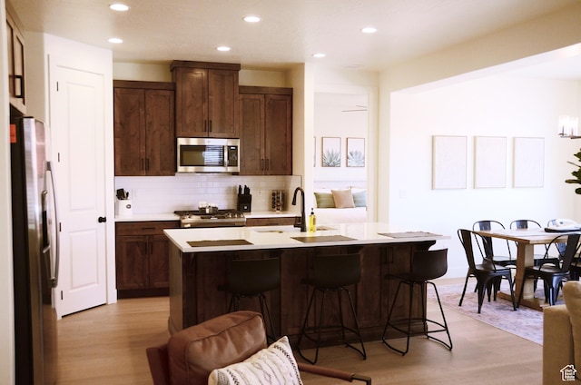 1376 Rustico, Washington, UT 84780 - kitchen featuring appliances with stainless steel finishes, a sink, backsplash, light wood-style flooring, and recessed lighting