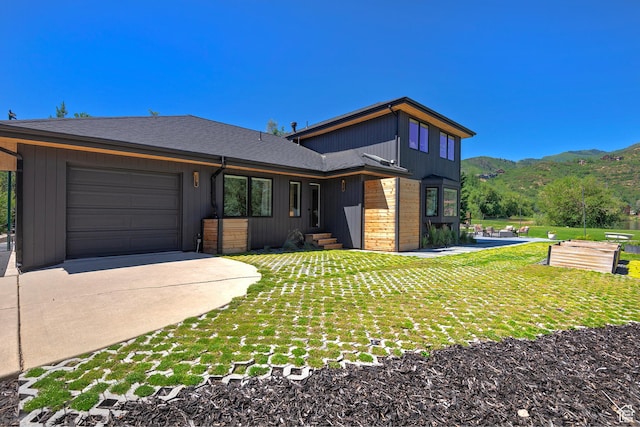 1504 Lake Front Ct, Park City, UT 84098 - modern home featuring concrete driveway, an attached garage, a mountain view, and a front lawn
