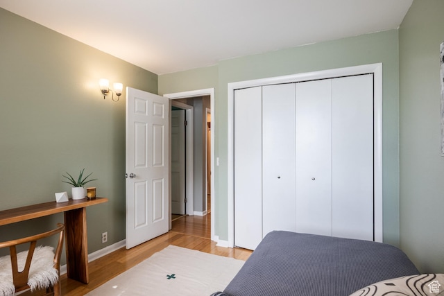 2660 E 3300 S Unit A-21, Salt Lake City, UT 84109 - bedroom featuring light wood-style floors, a closet, and baseboards