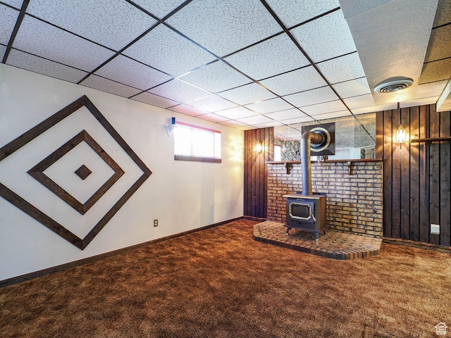 5747 S Sanford Dr, Murray, UT 84123 - unfurnished living room featuring carpet flooring, a wood stove, a drop ceiling, baseboards, and wood walls