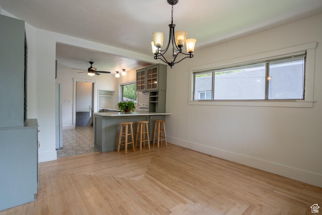 354 N 200 E, Logan, UT 84321 - kitchen featuring baseboards, a peninsula, plenty of natural light, and a chandelier