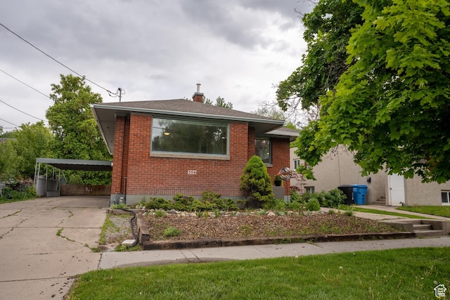 354 N 200 E, Logan, UT 84321 - bungalow with brick siding, driveway, a carport, and a chimney