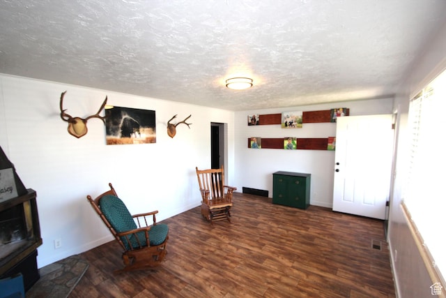 324 W 600 N, Logan, UT 84321 - sitting room featuring wood finished floors, a textured ceiling, baseboards, and a wood stove