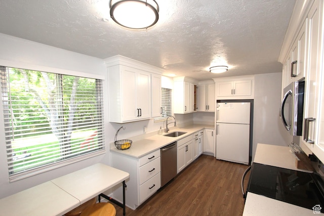 324 W 600 N, Logan, UT 84321 - kitchen with stainless steel appliances, a sink, light countertops, a textured ceiling, and dark wood-style floors
