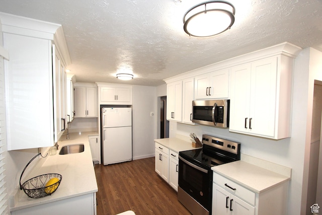 324 W 600 N, Logan, UT 84321 - kitchen featuring appliances with stainless steel finishes, a sink, light countertops, white cabinetry, and dark wood-style floors